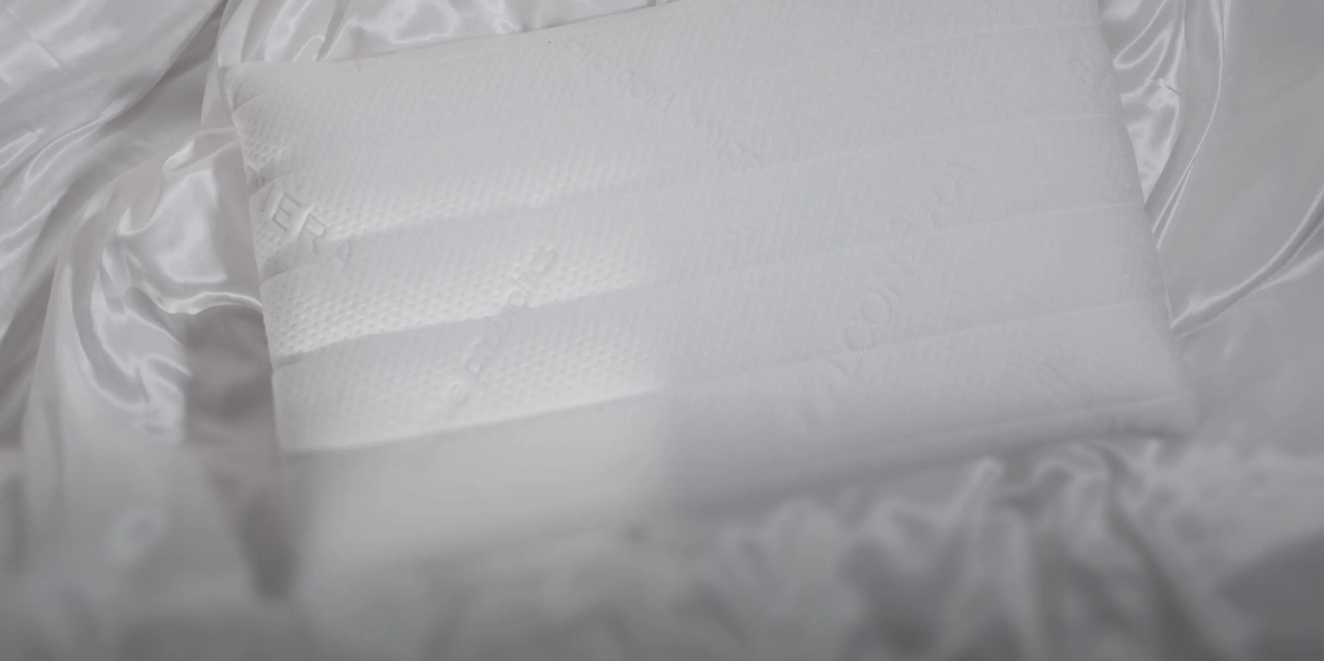 Loonéra Glow Cover liegt auf heller Bettwäsche